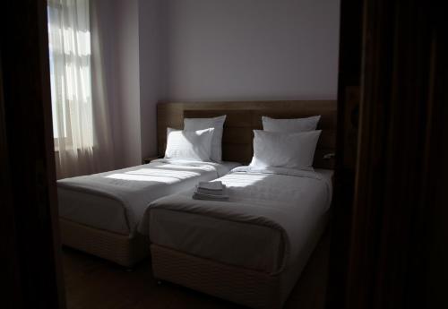 a bedroom with two beds with white sheets and pillows at KUMA Hotel Gyumri in Gyumri