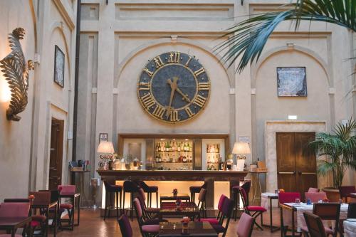um grande relógio na parede acima de um bar em um restaurante em Grand Hotel Continental Siena - Starhotels Collezione em Siena