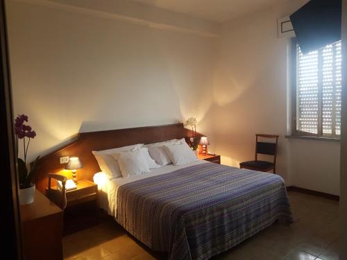 1 dormitorio con 1 cama, 2 lámparas y ventana en Albergo Smeraldo, en Castelnuovo Magra