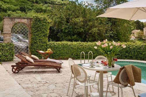 een patio met een tafel en stoelen naast een zwembad bij Villa Ava Kotor in Kotor