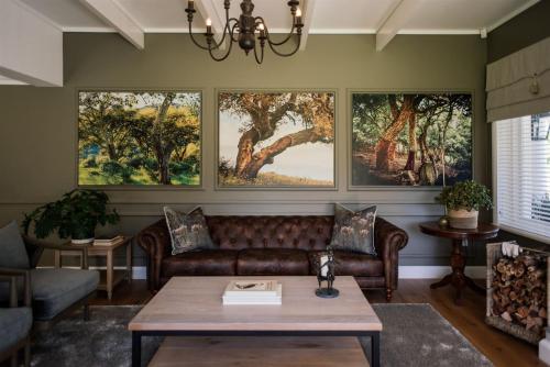 a living room with a couch and paintings on the wall at Woodlands Villa in George