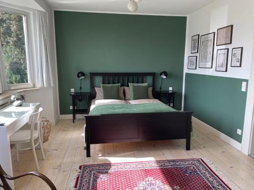 1 dormitorio con cama y pared verde en Attendorner Burgblick, en Attendorn