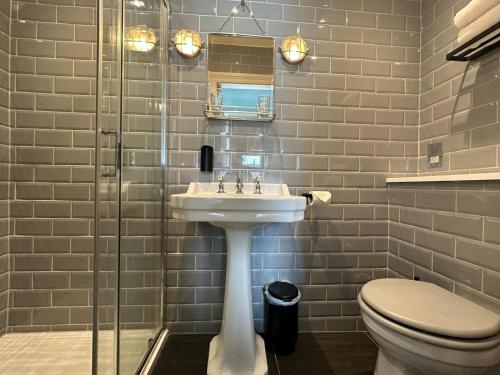 a bathroom with a sink and a toilet at Rooms Above Sugar Boat in Helensburgh