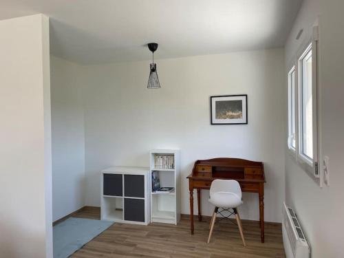 Cette chambre blanche dispose d'un bureau et d'une chaise. dans l'établissement La Grenouillère, à Cléder