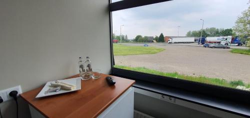 uma janela num quarto com uma mesa e vista para um parque de estacionamento em Hiway Motel em Siebengewald