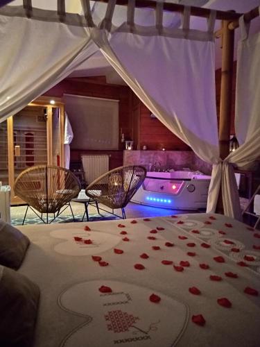 1 dormitorio con 1 cama con rosas en el suelo en Suite avec SPA et SAUNA privatif, en Vallères