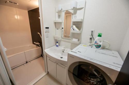 a bathroom with a sink and a washing machine at Funhouse-to-101 North Umeda 12ppl Condo in Osaka