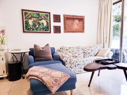 sala de estar con silla azul y sofá en Mossy Forest Family Retreat, Kea Farm Brinchang, en Brinchang