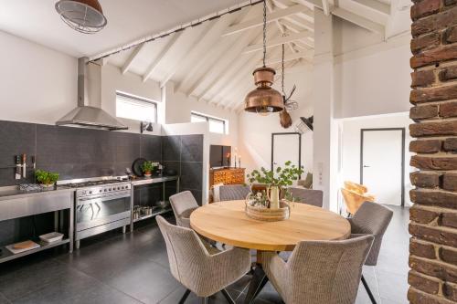 Una cocina y un comedor con mesa y sillas de madera. en Villa La Chatelaine, en Egmond aan Zee