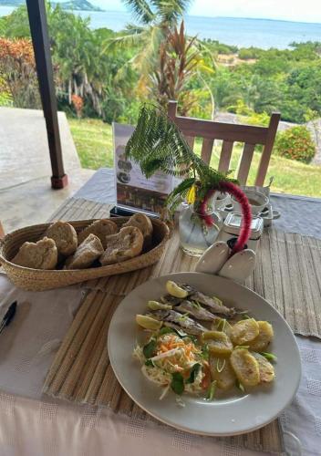 a table with a plate of food and a basket of bread at WINGS HOTELS in Nosy Be