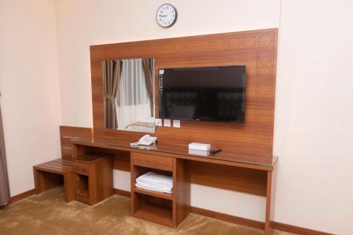 a room with a desk with a tv and a mirror at فندق منار التوحيد 2 in Mecca