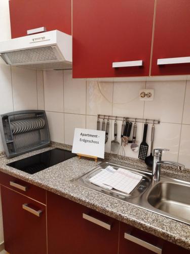 um balcão de cozinha com um lavatório e um sinal nele em 3 x Ferien- & Monteurwohnungen Koenen nah am Westfield Centro em Oberhausen