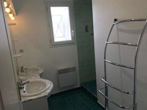 baño con 2 lavabos y ventana en Résidence les Trémières, en Bourcefranc