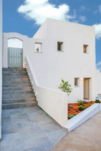 a white house with stairs leading up to it at Makrikythera Luxury Suites - Private Pool or Hot Tub Suites in Dhiakofti