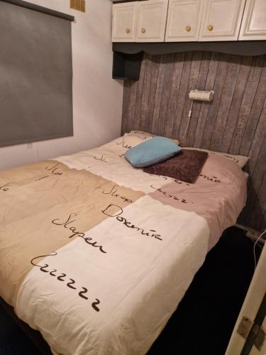 een bed met een opschrift op een kamer bij Ruime chalet nabij Giethoorn in De Pol