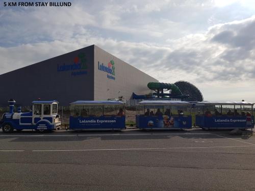a train with people on it in front of a building at STAY Billund in Vandel