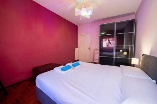 a bedroom with a white bed and a purple wall at Casa Labertino in Rome