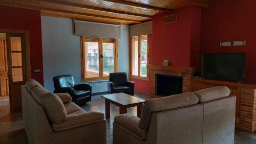 uma sala de estar com cadeiras, uma televisão e uma mesa em Camping Caravaning Cuenca em Cuenca