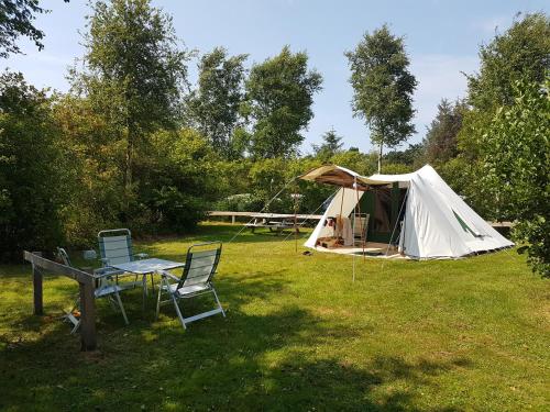 ein Zelt und ein Tisch und Stühle im Hof in der Unterkunft Ameland tentenverhuur Ameland in Nes