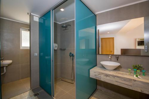 a bathroom with a glass shower and a sink at Balos Beach in Kissamos