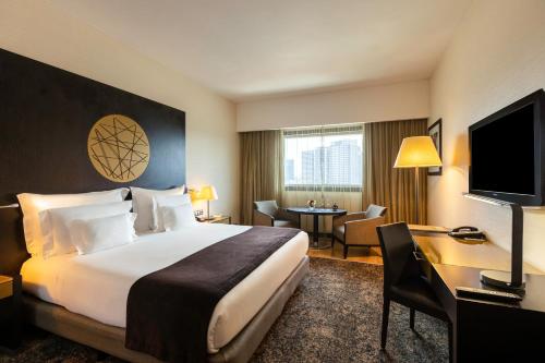 羅安達的住宿－EPIC SANA羅安達酒店，酒店客房配有一张床、一张书桌和一台电视。