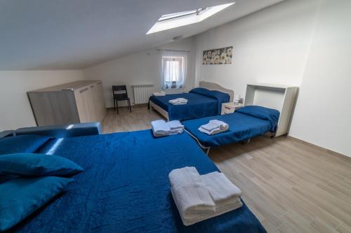 a room with two blue beds and a couch at Il Vicoletto in Bosco