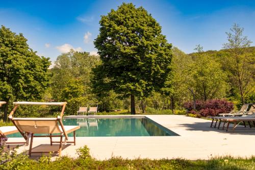 a swimming pool with a chair and a table at Musella Winery & Relais in San Martino Buon Albergo