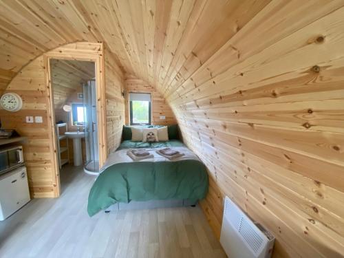 a bedroom in a log cabin with a bed in it at Glamping at Share Discovery Village in Lisnaskea