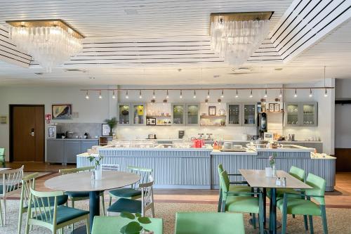 a restaurant with tables and chairs and a kitchen at Good Morning + Helsingborg in Helsingborg