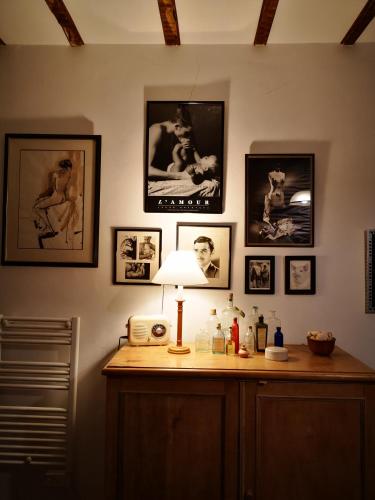 a room with a table with a lamp and pictures on the wall at Mulé, Route du Mulé in Lagardère