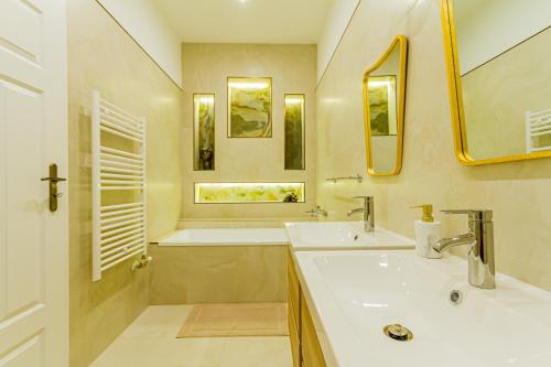 a bathroom with two sinks and a tub and a mirror at Bengt Apartment Kiraly Str. Luxury Suite in Budapest