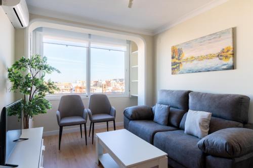 uma sala de estar com um sofá e duas cadeiras em Conde Collection Santa Justa em Sevilha