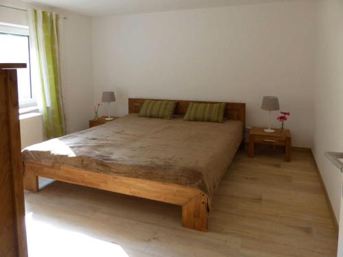 een slaapkamer met een groot bed en 2 tafels bij Ferienwohnungen am Waldessaum in Bodstedt