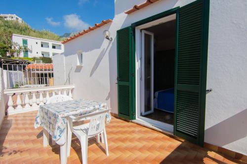 a patio with a table and chairs on a balcony at Lucia Maison in Ischia