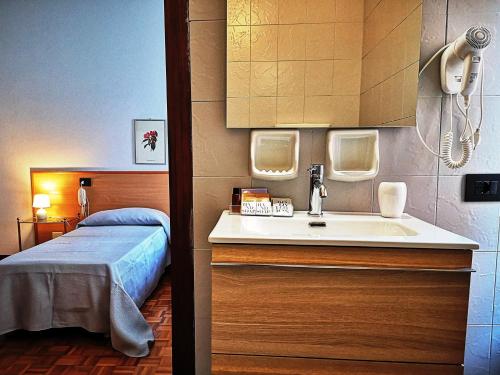 a bathroom with a sink and a bed at ALBERGO BALDAZZI 1916 in Zavattarello