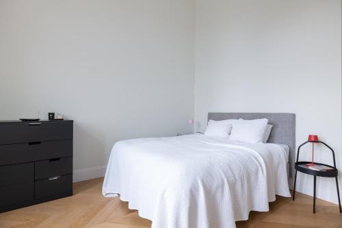 - une chambre avec un lit blanc et une commode noire dans l'établissement Stunning Apartment in City Center, à Vienne