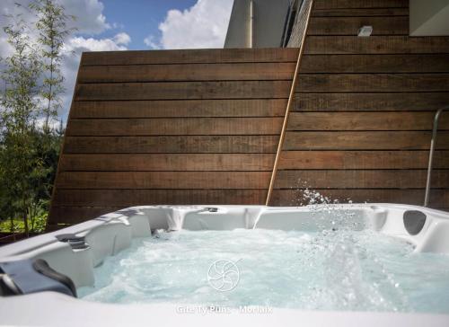 a jacuzzi tub in front of a building at Ty Puns - Gîte écoresponsable dans un espace verdoyant en centre-ville in Morlaix
