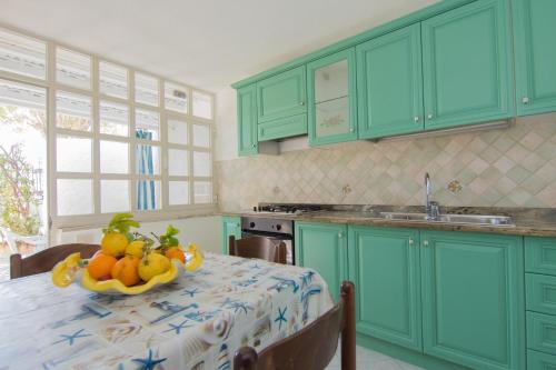a kitchen with a table with a bowl of fruit on it at Lucia Maison in Ischia