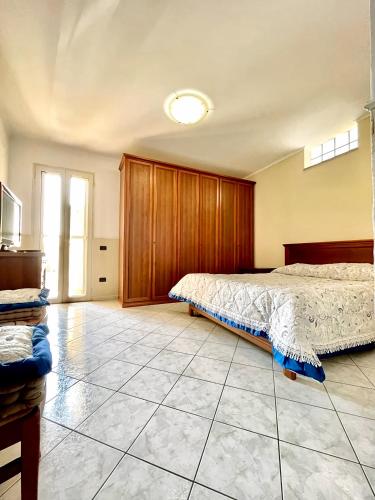 a bedroom with a bed and a tv on a tiled floor at Locazione Turistica Misano in Monte di Procida