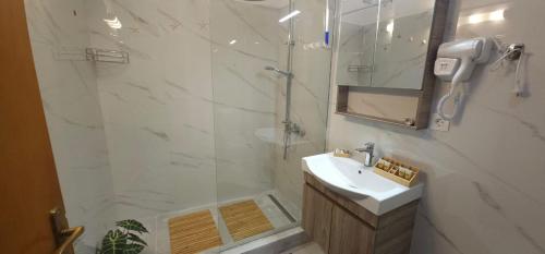 a bathroom with a shower and a sink and a mirror at FOTA'S HOME in Myrtos