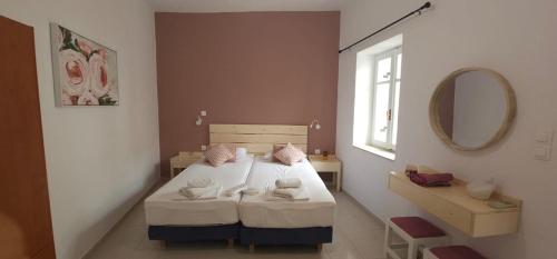 a small bedroom with a bed and a mirror at FOTA'S HOME in Myrtos