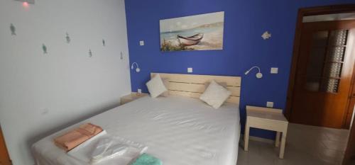 a bedroom with a bed with a blue wall at FOTA'S HOME in Myrtos