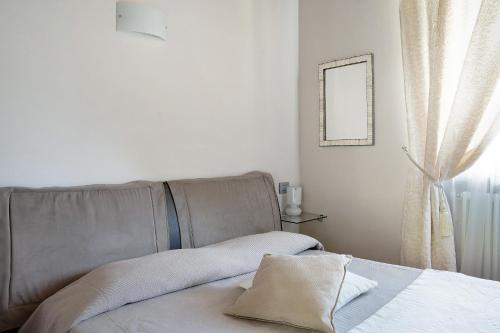 Schlafzimmer mit einem Bett, einem Spiegel und einem Fenster in der Unterkunft La Corte di Langa alloggio Quarzo in Albaretto Della Torre 