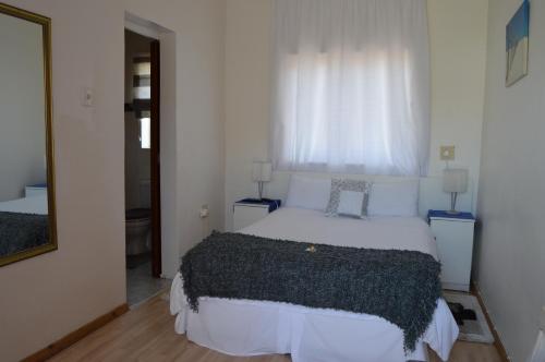 1 dormitorio con cama blanca y ventana en Villelodge Accommodation en Lüderitz