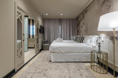 a bedroom with a large white bed and a lamp at Maison Marineta in Denia