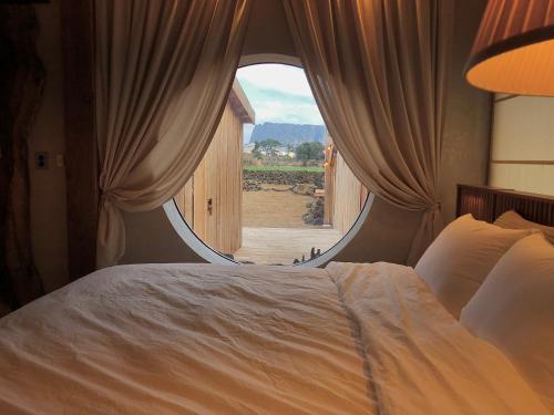 a bedroom with a large bed with a large window at 제주 전통 구옥을 현대식으로 해석한 Stay EUNWOL-OJO in Seogwipo
