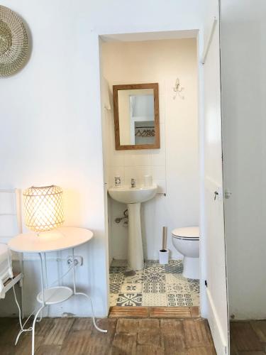 a bathroom with a sink and a toilet at Casa Largo do Poço Guesthouse in Alvor
