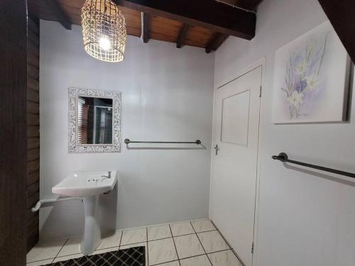 a white bathroom with a sink and a shower at Varswaterkloof Houthuis in Paarl