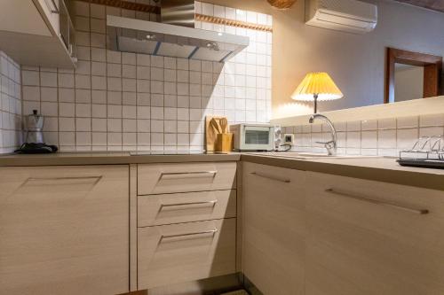 a kitchen with a sink and a microwave at Musella Winery & Relais in San Martino Buon Albergo