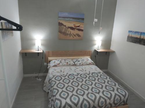 sypialnia z łóżkiem i 2 lampkami na ścianie w obiekcie Guest Room Santa Cruz w mieście Santa Cruz de Tenerife